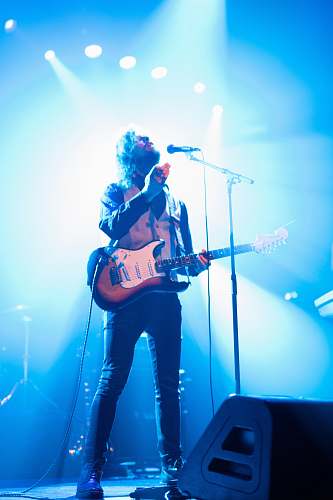 leisure activities man with electric guitar standing on stage guitar